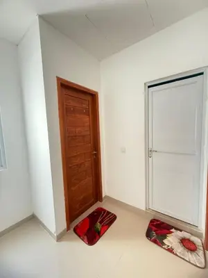 a white room with a door and a red rug at Home Stay Room in Bali Near Sanur Beach in Sanur
