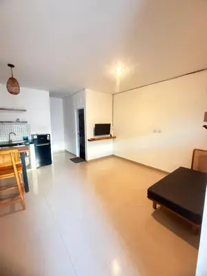 an empty living room with a table and a kitchen at Home Stay Room in Bali Near Sanur Beach in Sanur