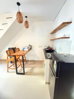 a kitchen with a wooden table and a dining room at Home Stay Room in Bali Near Sanur Beach in Sanur