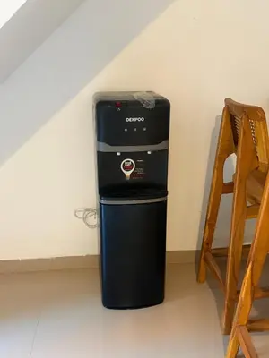 a small refrigerator in a room next to a chair at Home Stay Room in Bali Near Sanur Beach in Sanur
