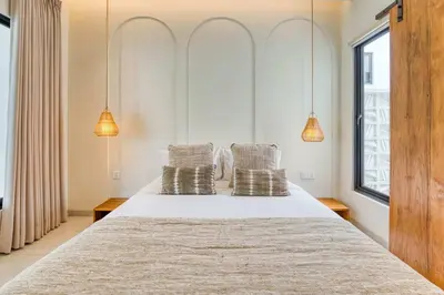 a bedroom with a bed with two pillows on it at Casa Amadeo Villas Seminyak in Seminyak