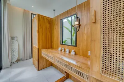 a bathroom with a wooden wall with a window at Casa Amadeo Villas Seminyak in Seminyak