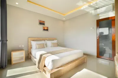 a bedroom with a bed in a white room at Narmada House Seminyak in Seminyak