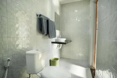 a bathroom with a white toilet and a sink at Narmada House Seminyak in Seminyak
