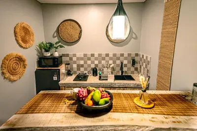 a kitchen with a bowl of fruit on a table at Amshiga 1 in Jimbaran