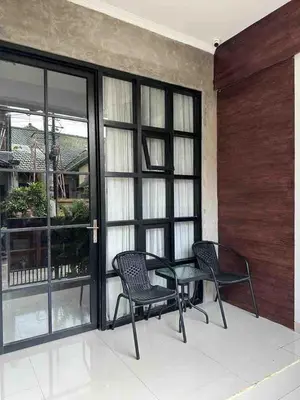 a patio with two chairs and a table and windows at Odua Mezzanine - Bromo in Denpasar