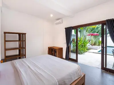 a bedroom with a bed and a sliding glass door at Villa Melissa in Kerobokan