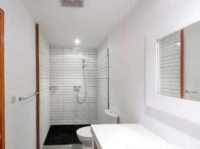 a white bathroom with a shower and a toilet at Villa Melissa in Kerobokan