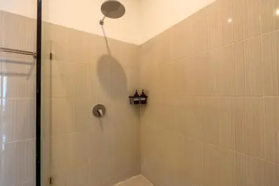 a shower with a shower head in a bathroom at Arts Heliconia Villa Two-Bedroom Private Pool Kuta in Kerobokan