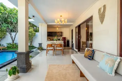a living room and kitchen with a couch and a table at Arts Heliconia Villa Two-Bedroom Private Pool Kuta in Kerobokan