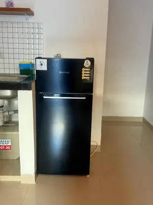 a black refrigerator in a kitchen next to a counter at Home Stay Room in Bali Near Sanur Beach in Sanur