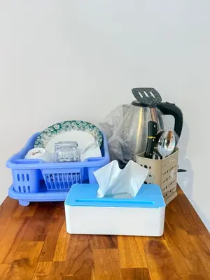 a blue laundry basket sitting on top of a wooden floor at Home Stay Room in Bali Near Sanur Beach in Sanur