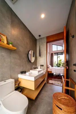 a bathroom with a sink and a toilet and a bedroom at Divija Villa by Unicorn Villas Bali in Kerobokan