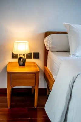 a bedroom with a bed and a table with a lamp at Divija Villa by Unicorn Villas Bali in Kerobokan
