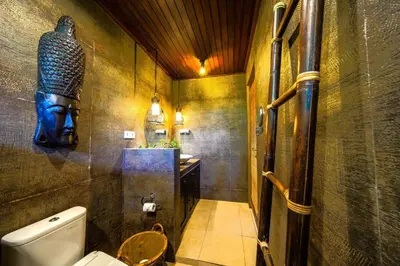a bathroom with a toilet and a statue on the wall at Villa ABBI Luxury 2 Bedroom Villa - Legian Seminyak in Seminyak