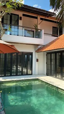 a house with a swimming pool in front of a house at Shivana Villa in Kerobokan