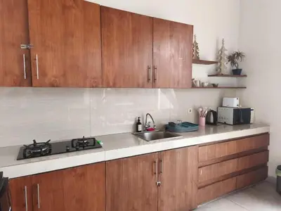 a kitchen with wooden cabinets and a sink at Modern Tropical 2BR Villa in Seminyak Kuta with Pool & Garden in Legian