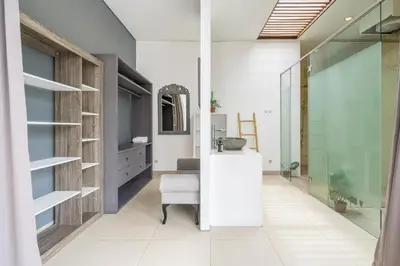 a bathroom with a sink and a chair in a room at Modern Tropical 2BR Villa in Seminyak Kuta with Pool & Garden in Legian