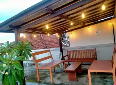 a patio with two benches and a table and awning at RBE Hotel Kuta 2- 5 Min to Airport&Beach by Micky Studio in Ngurah Rai International Airport