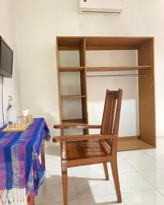 a wooden chair sitting in front of a table at RBE Hotel Kuta 2- 5 Min to Airport&Beach by Micky Studio in Ngurah Rai International Airport