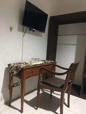 a desk with a chair and a television on a wall at RBE Hotel Kuta 2- 5 Min to Airport&Beach by Micky Studio in Ngurah Rai International Airport