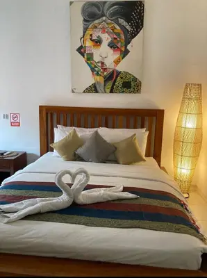 a bedroom with a bed with two swans on it at RBE Hotel Kuta 3- 5 Min to Airport&Beach by Micky Studio in Ngurah Rai International Airport