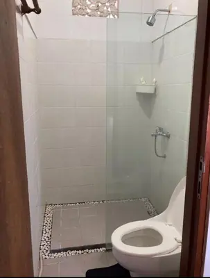 a bathroom with a toilet and a glass shower at RBE Hotel Kuta 3- 5 Min to Airport&Beach by Micky Studio in Ngurah Rai International Airport