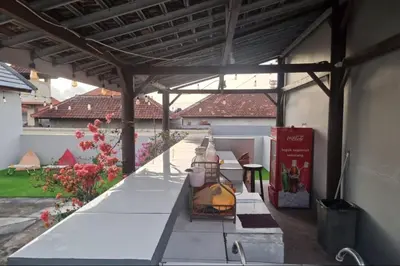 a patio with a wooden pergola and a table at RBE Hotel Kuta 4- 5 Min to Airport&Beach by Micky Studio in Ngurah Rai International Airport