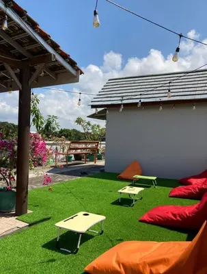 a backyard with green grass and red pillows and a building at RBE Hotel Kuta 4- 5 Min to Airport&Beach by Micky Studio in Ngurah Rai International Airport