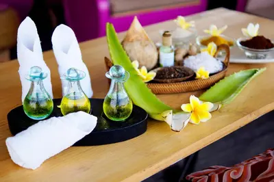 a table topped with bottles of soap and flowers at Koa D Surfer Hotel in Canggu