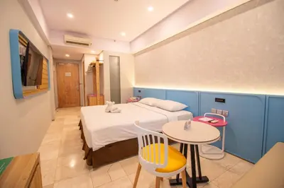 a bedroom with a bed and a table and chairs at Koa D Surfer Hotel in Canggu