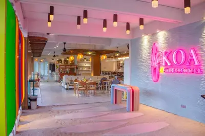 a restaurant with a neon sign on the wall at Koa D Surfer Hotel in Canggu