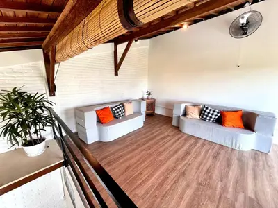 a living room with two couches and orange pillows at Villa Loba Sanur in Sanur