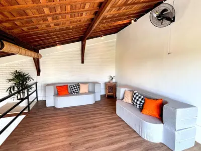 a living room with two couches and orange pillows at Villa Loba Sanur in Sanur