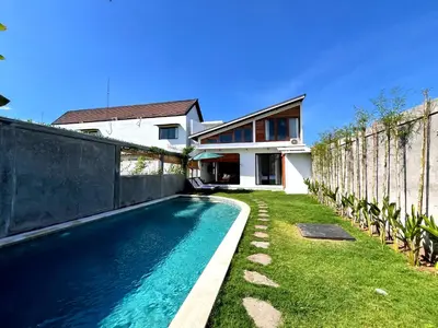 a swimming pool in front of a house at Villa Loba Sanur in Sanur