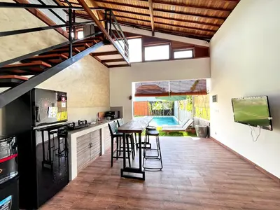 an open kitchen with a table and stools at Villa Loba Sanur in Sanur