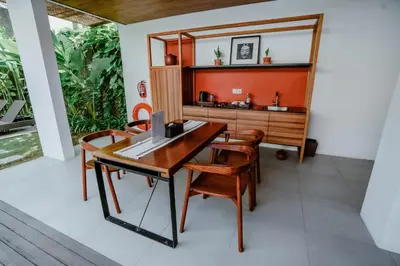 a dining room with a wooden table and chairs at Abia Villa Legian in Legian