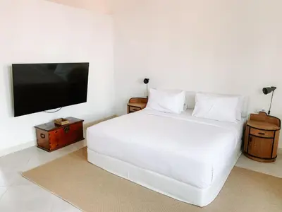 a bedroom with a white bed and a flat screen tv at Lovely 2 Bedroom Pool Villa Close to The Beach in Seminyak