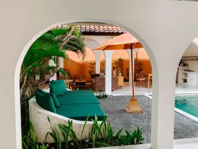 an archway with a couch and an umbrella next to a pool at Lovely 2 Bedroom Pool Villa Close to The Beach in Seminyak