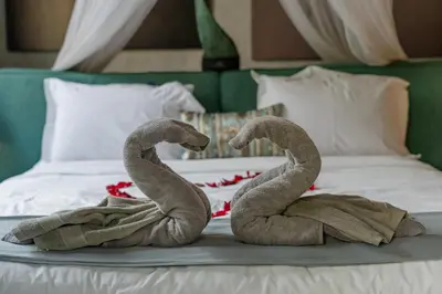 two towel animals sitting on top of a bed at Semesta Collection Seminyak Villas in Seminyak