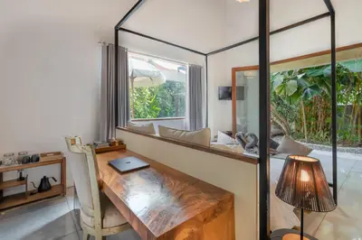 a room with a wooden table and a window at Semesta Collection Seminyak Villas in Seminyak