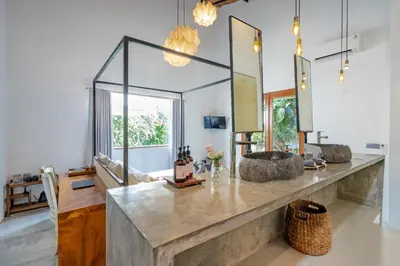a bathroom with a large stone counter with mirrors at Semesta Collection Seminyak Villas in Seminyak