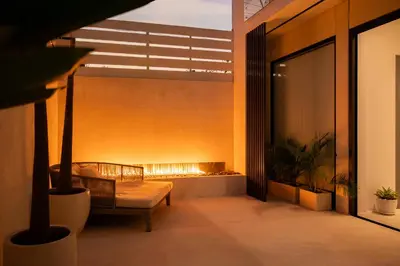 a balcony with a couch and a fire place at Villa Amare in Kerobokan