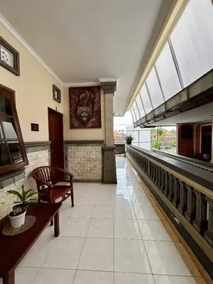 an empty lobby with a bench and a painting on the wall at Will and Ray's at Lori Beach Inn in Seminyak