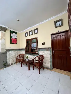a room with two chairs and a table and a door at Will and Ray's at Lori Beach Inn in Seminyak