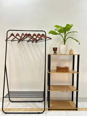 a shelf with a white curtain and a plant at Will and Ray's at Lori Beach Inn in Seminyak