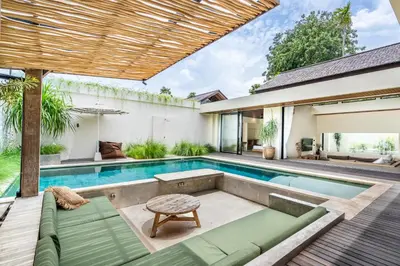 an outdoor swimming pool with a villa at Kin House Bali in Seminyak
