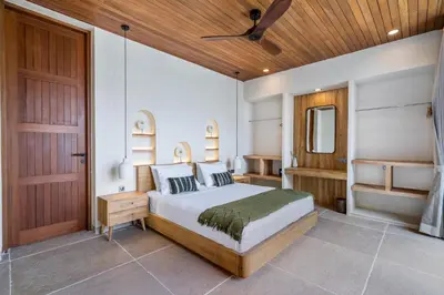 a bedroom with a bed and a wooden ceiling at Kin House Bali in Seminyak