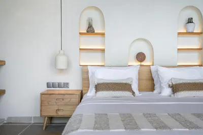 a bedroom with a large white bed with white pillows at Kin House Bali in Seminyak