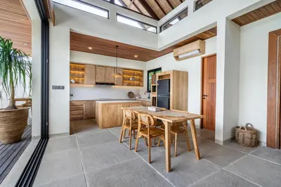 a kitchen with a wooden table and chairs at Kin House Bali in Seminyak